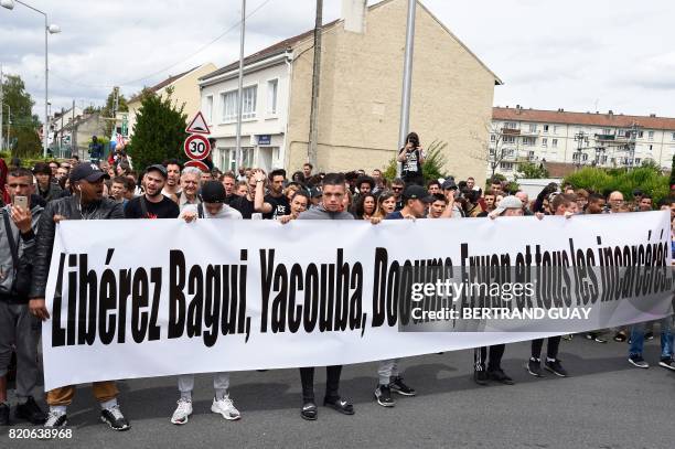 People take part in a commemorative march on July 22, 2017 in Beaumont-sur-Oise, northeast of Paris, in memory of Adama Traore, who died during his...