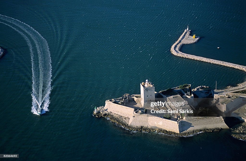Boat passing along the fort of Fos-Sur-Mer, France (aerial view)
