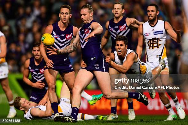 Daniel Howe of the Hawks is tackles Cam McCarthy of the Dockers on a snap on goal during the 2017 AFL round 18 match between the Fremantle Dockers...