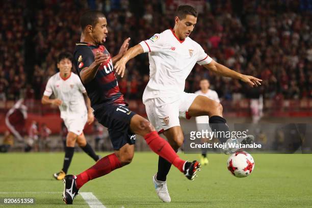 Wissam Ben Yedder of Sevilla and Bueno of Kashima Antlers compete for the ball during the preseason friendly match between Kashima Antlers and...