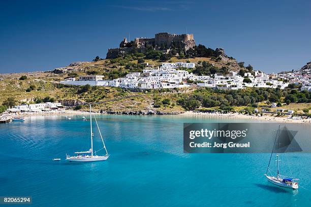 lindos with beach + acropolis - ilhas do dodecaneso imagens e fotografias de stock
