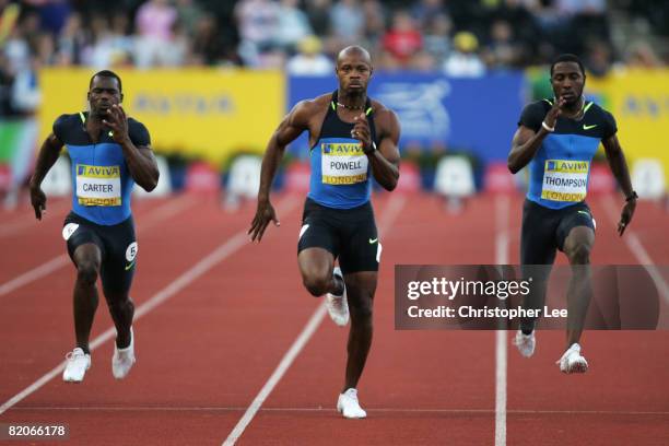 Asafa Powell of Jamaica competes in the Men's 100 Metres Final with Nesta Carter of Jamaica and Richard Thompson of Trinidad and Tobago during day 1...