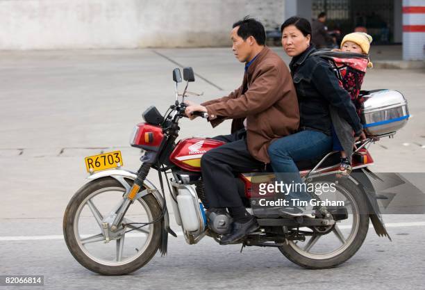 Couple with child on motorbike in Guilin, China, China has a one child family planning policy to reduce population,