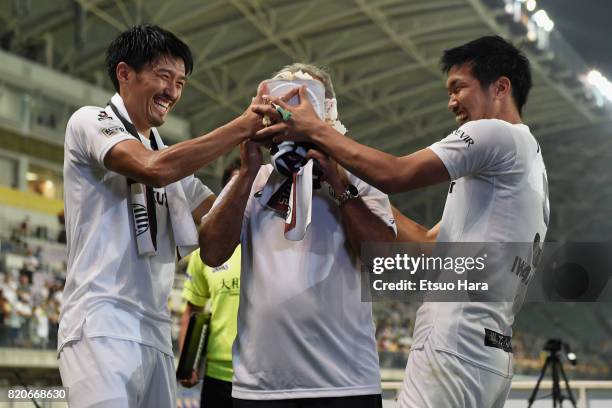 Head coach Nelsinho of Vissel Kobe is pushed the birthday cake by Hirofumi Watanabe and Shuhei Otsuki after the preseason friendly match between...