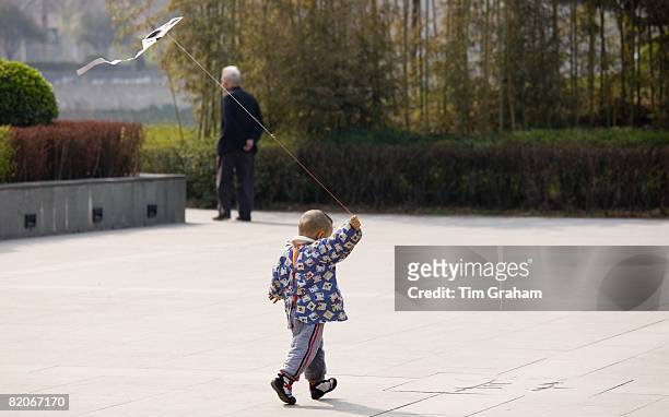Child playing with a kite in the park by the City Wall, Xian, China has a one child policy to limit population,