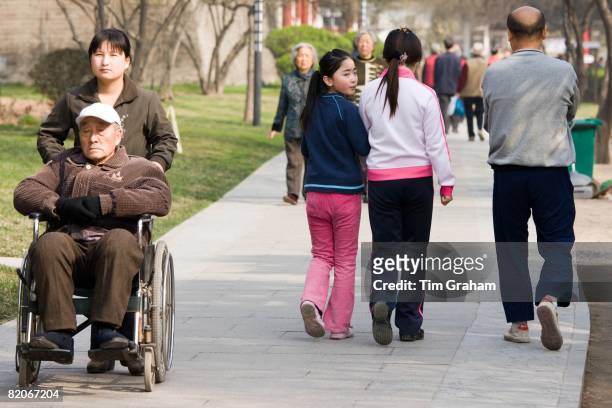 People stroll through park by the City Wall, Xian, China has a one child policy to limit population,