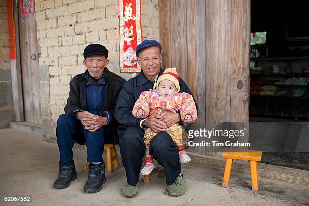 Men with a young baby in Fuli Old Town, Xingping, China has a one child policy to limit population,