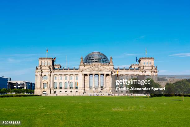 reichstag building on a sunny day with clear blue sky and lawn with green grass - reichstag photos et images de collection