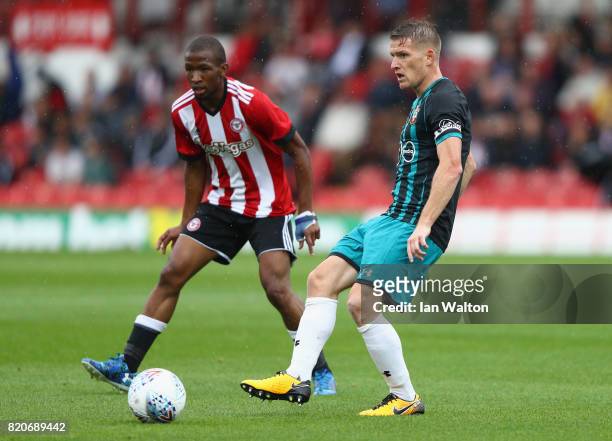 Kamo Mokotjo of Brentford tries to tackle Charlie Austin of Southampton during the Pre Season Friendly match between Brentford and Southampton at...