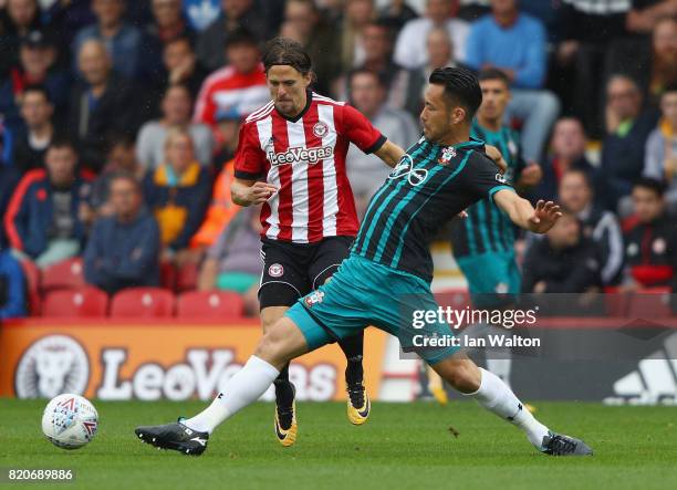 Lasse Vibe of Brentford is tackled by Maya Yoshida of Southampton during the Pre Season Friendly match between Brentford and Southampton at Griffin...