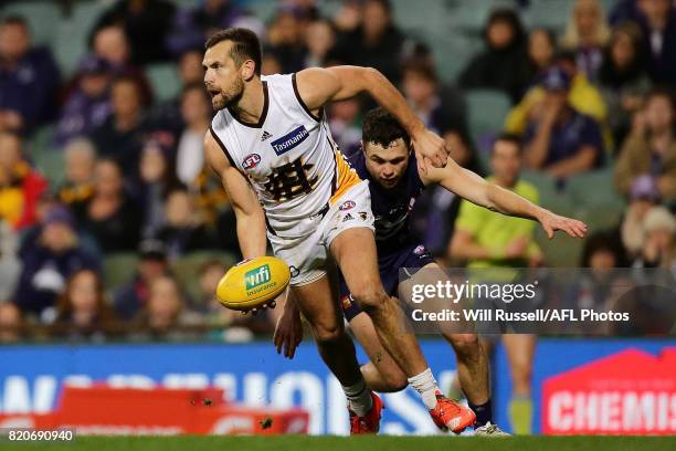 Luke Hodge of the Hawks controls the ball under pressure from Hayden Ballantyne of the Dockers during the round 18 AFL match between the Fremantle...