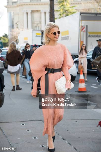 Fashion blogger Caroline Daur wears Dior shoes, Jil Sander dress, Loewe bracelet Miu Miu bag on day 3 during Paris Fashion Week Autumn/Winter 2017/18...