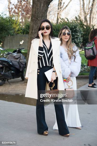 Rita Hsieh wears a Chloe top, jacket and bag, Linda farrow sunglasses and Derek Lam trousers with aguest wearing a Chloe bag on day 3 during Paris...