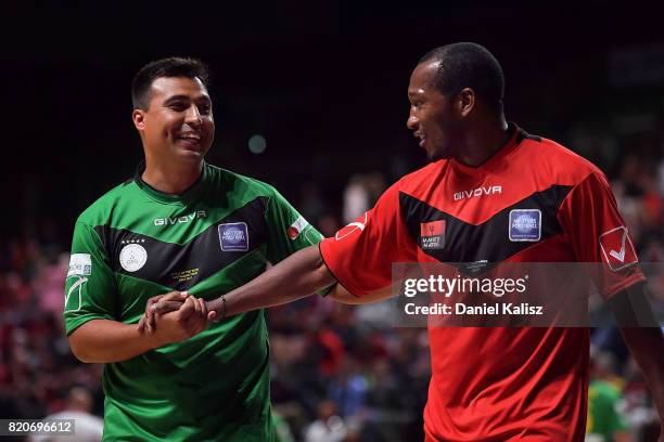 Nick Carle of the Socceroos shakes hands with Eric Djemba Djemba of Manchester United during the match between the Socceroos Legends and the...