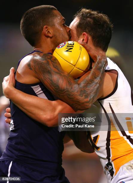 Bradley Hill of the Dockers gets tackled by Billy Hartung of the Hawks during the round 18 AFL match between the Fremantle Dockers and the Hawthorn...