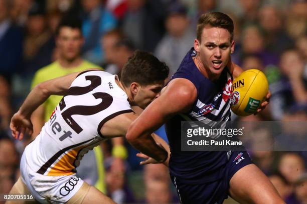 Ryan Nyhuis of the Dockers evades a tackle by Luke Breust of the Hawks during the round 18 AFL match between the Fremantle Dockers and the Hawthorn...
