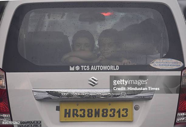Children in a car during a rain at Pargati Maidan, on July 22, 2017 in New Delhi, India. The rains brought much respite to the residents from the...