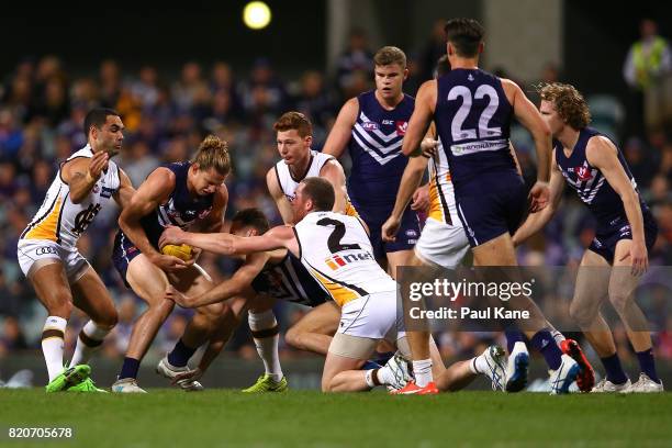 Nathan Fyfe of the Dockers contests for the ball against Shaun Burgoyne and Jarryd Roughead of the Hawks during the round 18 AFL match between the...