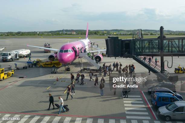 Airbus A320 form the Hungarian and Polish low cost airline Wizz Air. Tourists on the tarmac of the airport.