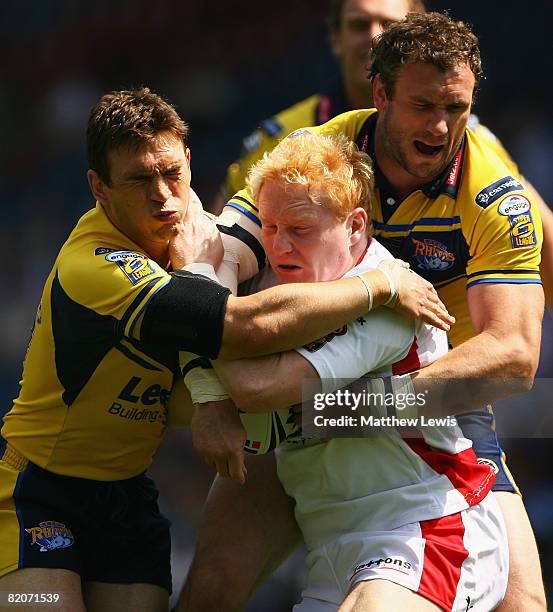 Kevin Sinfield and Jamie Peacock of Leeds tackle James Graham of St.Helens during the Carnegie Challenge Cup Semi Final match between Leeds Rhinos...