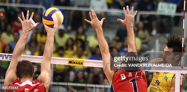 Brazil's Gilberto Godoy spikes the ball against US Lloy Ball and David Lee's blockade during their International Volleyball Federation World League...