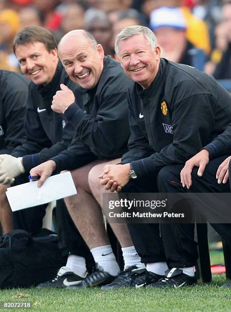 Sir Alex Ferguson and Mike Phelan of Manchester United watch from the bench during the Vodacom Challenge pre-season friendly match between Kaizer...