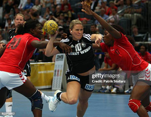 Anja Althaus of Germany battles against Isabel Fernandez and Elizabeth Viegas of Angola during the women's international friendly handball match...