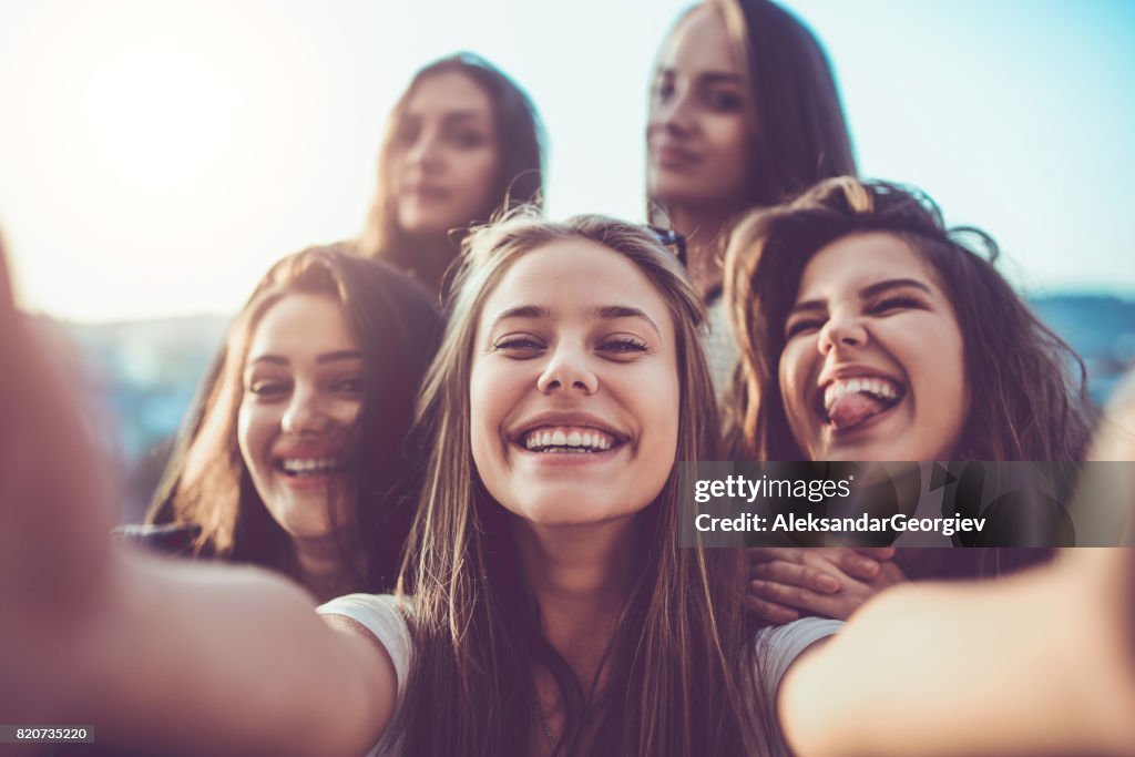 Group of Crazy Girls Taking Selfie and Making Faces Outdoors