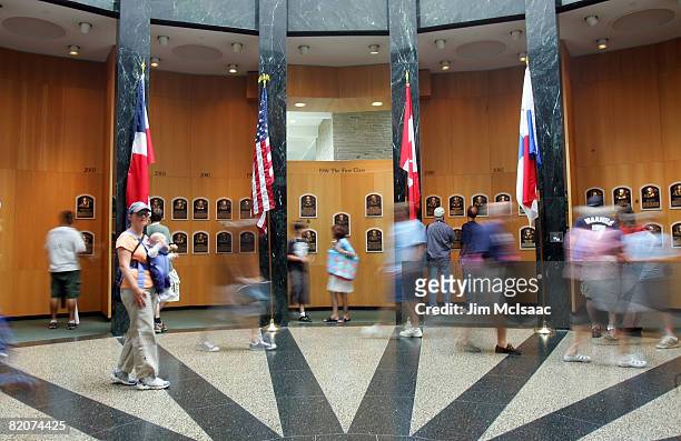 Baseball fans look at plaques of players inducted into the National Baseball Hall of Fame and Museum during the Baseball Hall of Fame weekend on July...