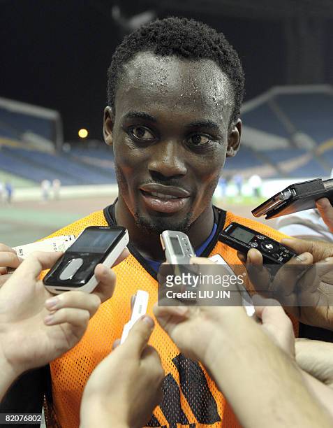 Chelsea football club's midfielder Michael Essien from Ghana is surrounded by journalists as he answers questions after a training session in China's...