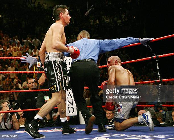 Referee Kenny Bayless steps in after Antonio Margarito knocked down Miguel Cotto during their WBA welterweight title fight at the MGM Grand Garden...