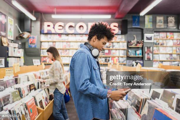 teenage boy in record store shopping for music - teenager boy shopping bildbanksfoton och bilder