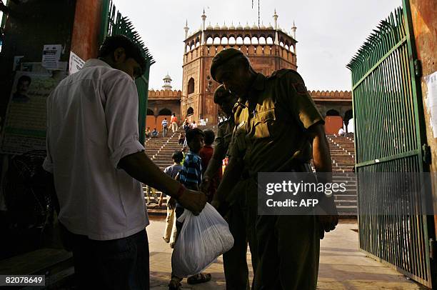 An Indian policeman checks the bag of a man visiting the Jama Masjid mosque in New Delhi on July 27 after security was put on high alert across the...