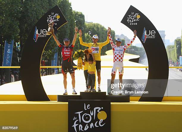 Yellow Jersey overall race winner Carlos Sastre of Spain and Team CSC Saxobank celebrates on the podium between Cadel Evans of Australia and...