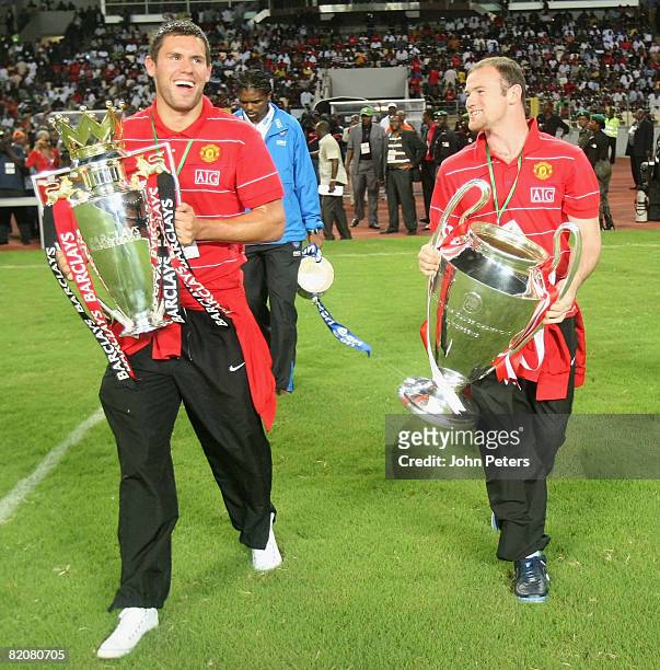 Wayne Rooney and Ben Foster of Manchester United show off the FA Barclays Premiership trophy and UEFA Champions League trophy ahead of the pre-season...
