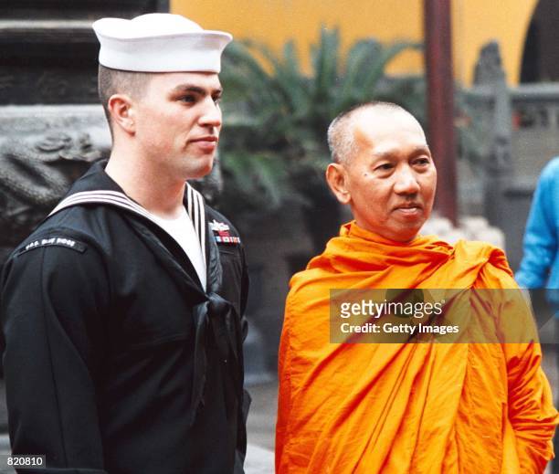 Todd Jensen of Littleton, Colo., observes the sights of the Temple of the Jade Buddha with a Buddhist Monk March 24, 2001 in Shanghai. Sailors from...