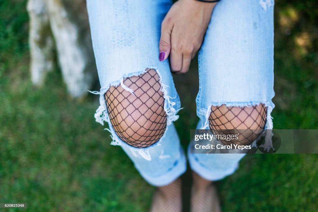 Above view of young wearing torn denim trousers