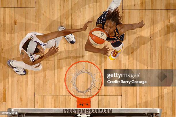 Tamika Catchings of the Indiana Fever shoots against Tangela Smith of the Phoenix Mercury on July 27 at U.S. Airways Center in Phoenix, Arizona. NOTE...