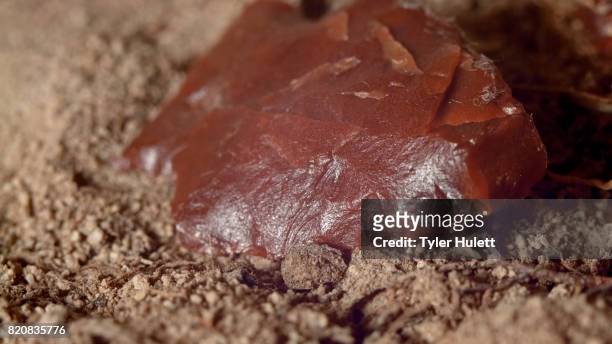 close up of native american red arrowhead jasper chert paiute indian stone tool in dirt from oregon great basin desert - chert stock pictures, royalty-free photos & images