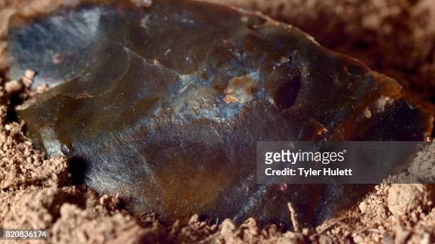 close up of native american broken hand axe ax jasper chert paiute indian stone tool in dirt from oregon great basin desert - obsidian stock pictures, royalty-free photos & images