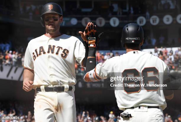 Conor Gillaspie of the San Francisco Giants is congratulated by Gorkys Hernandez after Gillaspie scored on a pitch-hit double from Buster Posey...