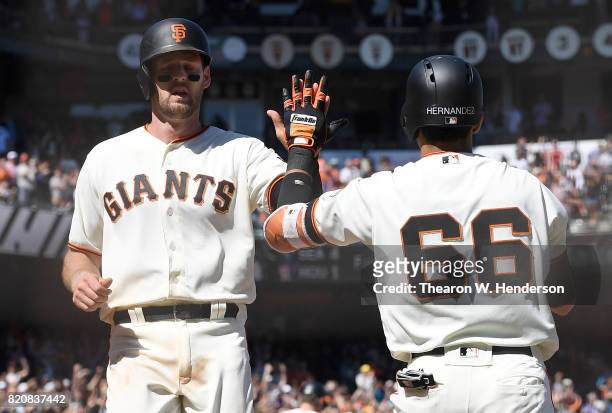 Conor Gillaspie of the San Francisco Giants is congratulated by Gorkys Hernandez after Gillaspie scored on a pitch-hit double from Buster Posey...