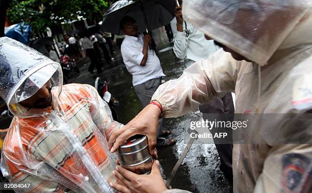 An Indian policeman inspects a tiffin box outside the Bombay Stock Exchange in Mumbai on July 28, 2008 following the bomb attacks in the western city...