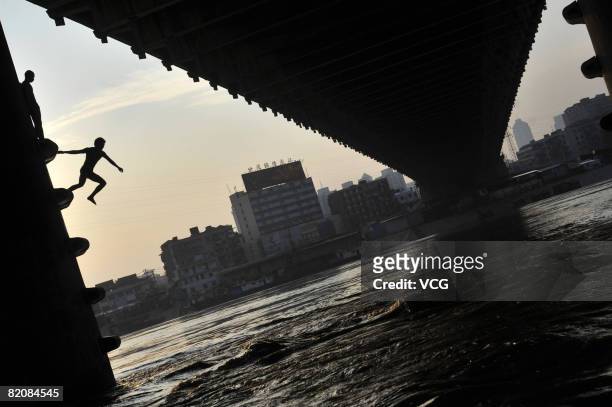 Boy jumps into the Hanjiang River from a bridge in Wuhan on July 26, 2008 capital city of Hubei province, central China. Wuhan saw the hottest day so...