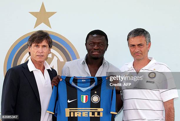 Sulley Ali Muntari of Ghana shows his new Inter Milan jersey next to Inter Milan coach Jose Mourinho and manager Gabriele Oriali during his official...