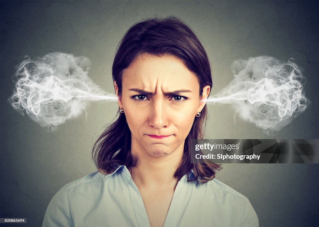 Angry young woman, blowing steam coming out of ears