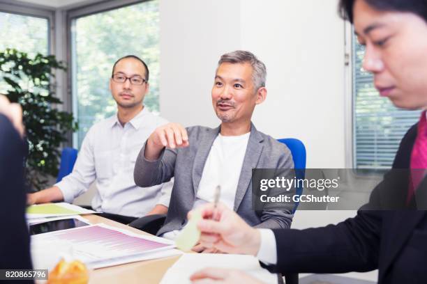 zaakvoerder blijkt zijn inzicht te werknemers - meeting candid office suit stockfoto's en -beelden