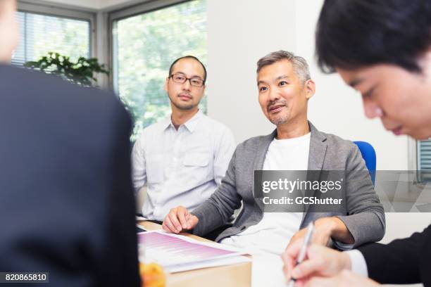 senior chairperson giving his opinion in a meeting - meeting candid office suit stock pictures, royalty-free photos & images