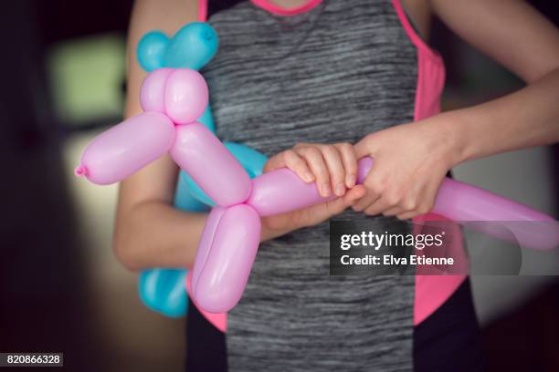 teenager making animal balloons - twisted imagens e fotografias de stock