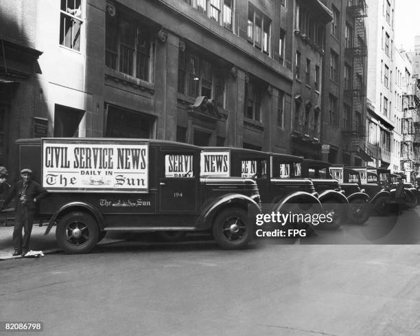 Vans parked outside the headquarters of The Sun newspaper in New York City, advertising the Civil Service News, circa 1930.